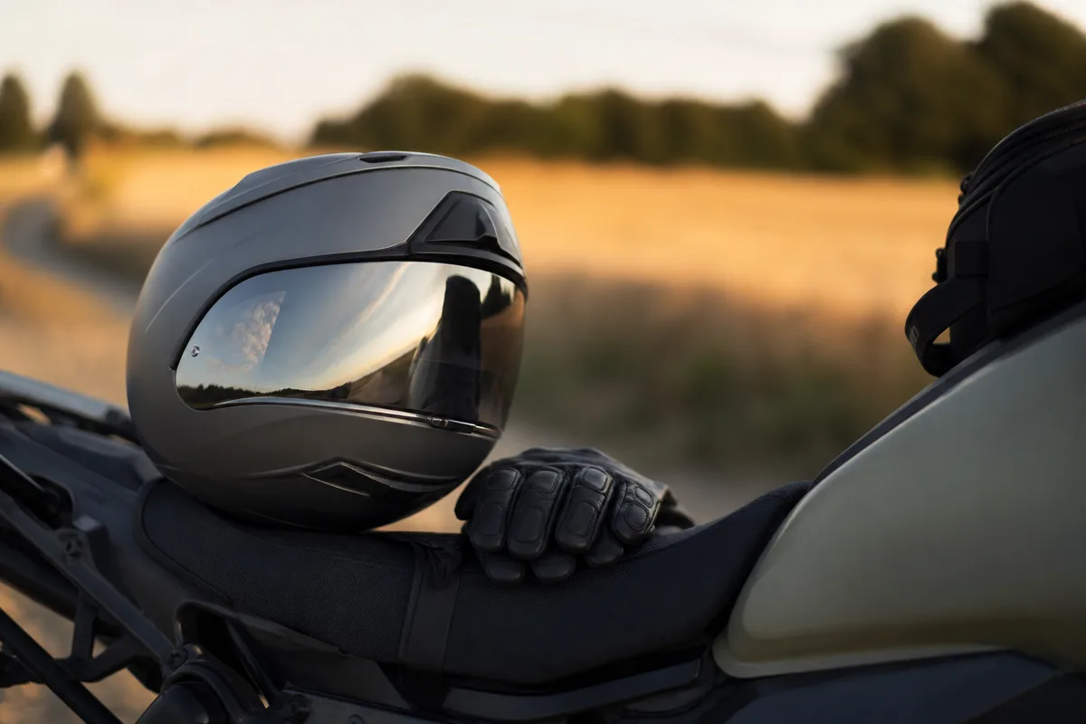 Casque intégral posé sur une selle de moto trail devant un paysage de campagne française