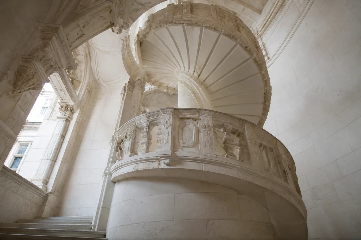 Escalier Renaissance en pierre claire vu en contre-plongée dans la cour d&rsquo;un château ligérien